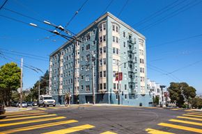 San Francisco apartment for rent - A street view of a blue building with a yellow crosswalk in front.