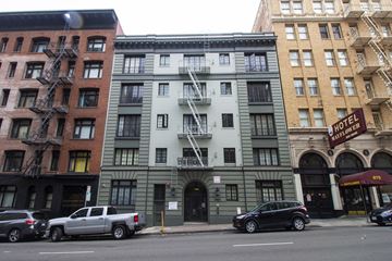 San Francisco apartment for rent - A street view of a hotel with cars parked in front.
