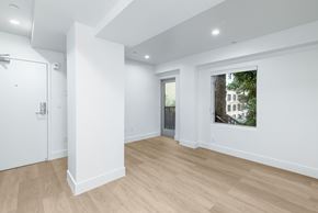 San Francisco apartment for rent - A room with a white door and a window with a view of a building outside.
