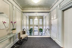 San Francisco apartment for rent - A hallway with a chair, a plant, and a mirror on the wall.