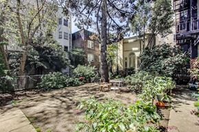 San Francisco apartment for rent - A backyard with a table and chairs surrounded by greenery.