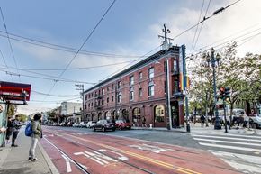 San Francisco apartment for rent - A street scene with a red brick building and a tram line running down the middle of the road.