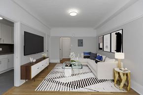 San Francisco apartment for rent - A modern living room with a white sofa, a coffee table, and a TV.