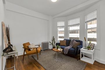 San Francisco apartment for rent - A living room with a blue couch and a brown chair.