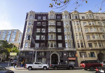 San Francisco apartment for rent - A tall building with a dark brown facade stands between two other buildings.