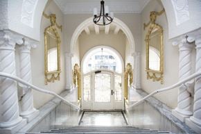 San Francisco apartment for rent - A staircase with a white railing and a chandelier hanging from the ceiling.