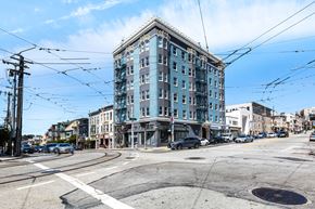 San Francisco apartment for rent - A street view of a city with a large building in the center.