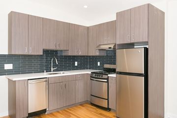 San Francisco apartment for rent - A kitchen with wooden cabinets and a black fridge.