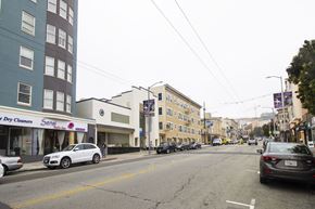 San Francisco apartment for rent - A street with cars parked on the side and a dry cleaners storefront.