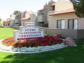 Glendale apartment for rent - a round sign in front of a building with flowers and rocks