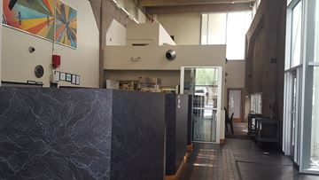Phoenix apartment for rent - a view into the kitchen from the lobby of a building with a black marble counter