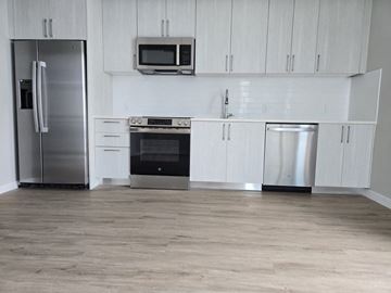 Miami apartment for rent - A kitchen with a refrigerator, oven, microwave, and dishwasher.