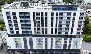 Miami apartment for rent - A tall white building with a mural of people on the bottom.