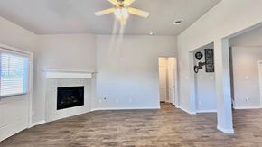 Angleton house for rent - a living room with a fireplace and a ceiling fan
