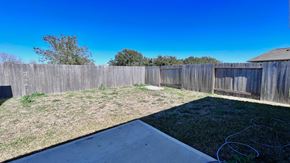 Angleton house for rent - a backyard with a fence and a yard with grass