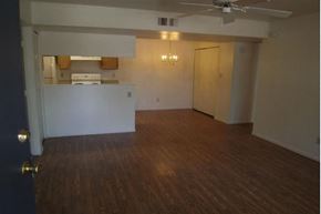Phoenix apartment for rent - an empty living room with a kitchen and a ceiling fan