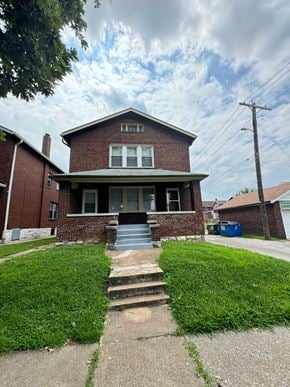 Saint Louis apartment for rent - the front of a brick house with stairs and grass