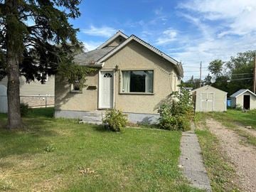 Prince Albert house for rent - a small tan house with a sidewalk in front of it