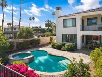 Indio apartment for rent - a backyard with a pool and a house with palm trees