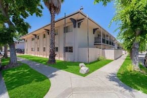 Sacramento apartment for rent - A building with a white fence and a green lawn in front.