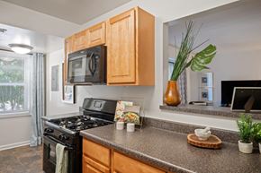 Windsor Mill townhouse for rent - A kitchen with a black stove top oven and wooden cabinets.