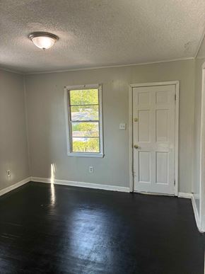 Prichard house for rent - A room with a white door and a window with a view of trees.