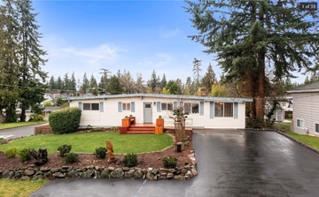 Federal Way house for rent - A house with a white exterior and a red door is surrounded by trees.
