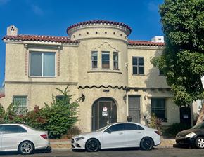 Long Beach apartment for rent - A white car is parked in front of a house with a red tile roof.
