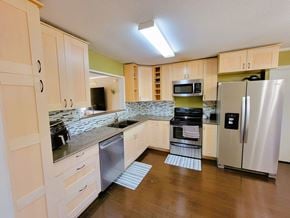 Killeen house for rent - a kitchen with stainless steel appliances and white cabinets