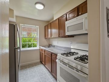 Washington apartment for rent - A kitchen with a white stove and brown cabinets.