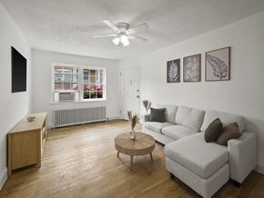 Washington apartment for rent - A living room with a white couch, wooden coffee table, and a ceiling fan.