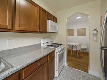 Washington apartment for rent - A kitchen with a white stove and wooden cabinets.