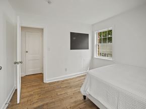 Washington apartment for rent - A bedroom with a bed, a door, and a window.