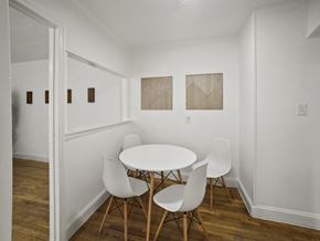 Washington apartment for rent - A white table with four chairs is in a room with white walls and wood floors.
