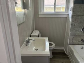 Akron house for rent - A white bathroom with a toilet, sink, and bathtub.
