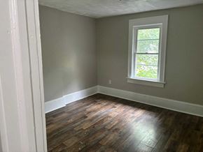Akron house for rent - A room with a window and wooden flooring.