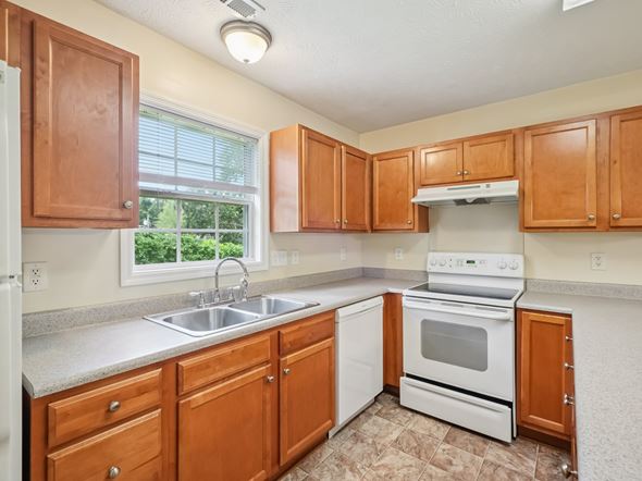 Fayetteville apartment for rent - A kitchen with wooden cabinets and white appliances.