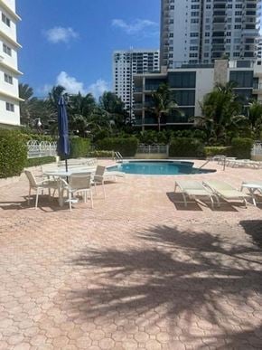 Hollywood apartment for rent - a pool with chairs and an umbrella next to a building