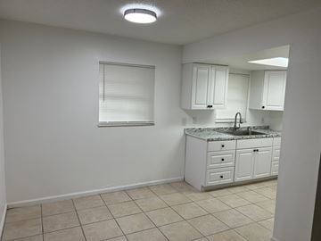 Vero Beach apartment for rent - A kitchen with white cabinets and a granite countertop.