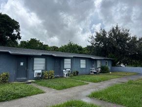 Vero Beach apartment for rent - A grey house with a blue sky and clouds in the background.