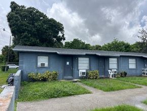 Vero Beach apartment for rent - A blue house with a grey roof and a grey car parked in front.