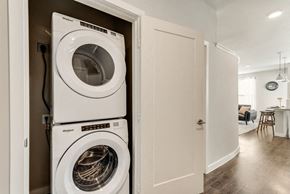 Mckinney house for rent - a front loading washer and dryer in a closet in a living room