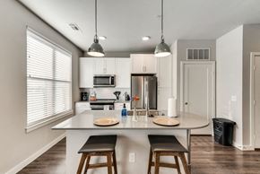 Mckinney house for rent - a kitchen with a large island with three stools