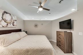 Mckinney house for rent - a bedroom with a large bed and a ceiling fan