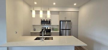 Calgary house for rent - a kitchen with a sink and a refrigerator