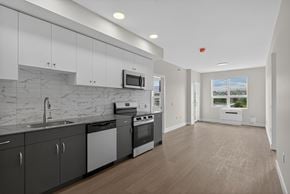 Kelowna apartment for rent - A modern kitchen with a marble backsplash and stainless steel appliances.