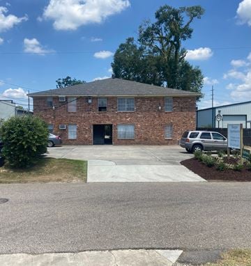 Baton Rouge apartment for rent - A brick building with a grey car in front.