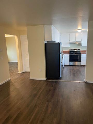 Everett apartment for rent - A black refrigerator in a kitchen with wooden floors.
