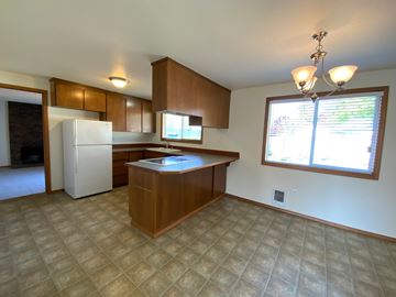 Everett house for rent - A kitchen with a white refrigerator and wooden cabinets.