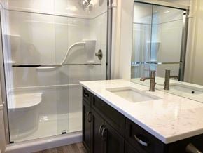 Brandon apartment for rent - A bathroom with a white sink and a glass shower stall.